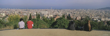 Four People Sitting on a Path with the Cityscape in the Background, Barcelona, Catalonia, Spain